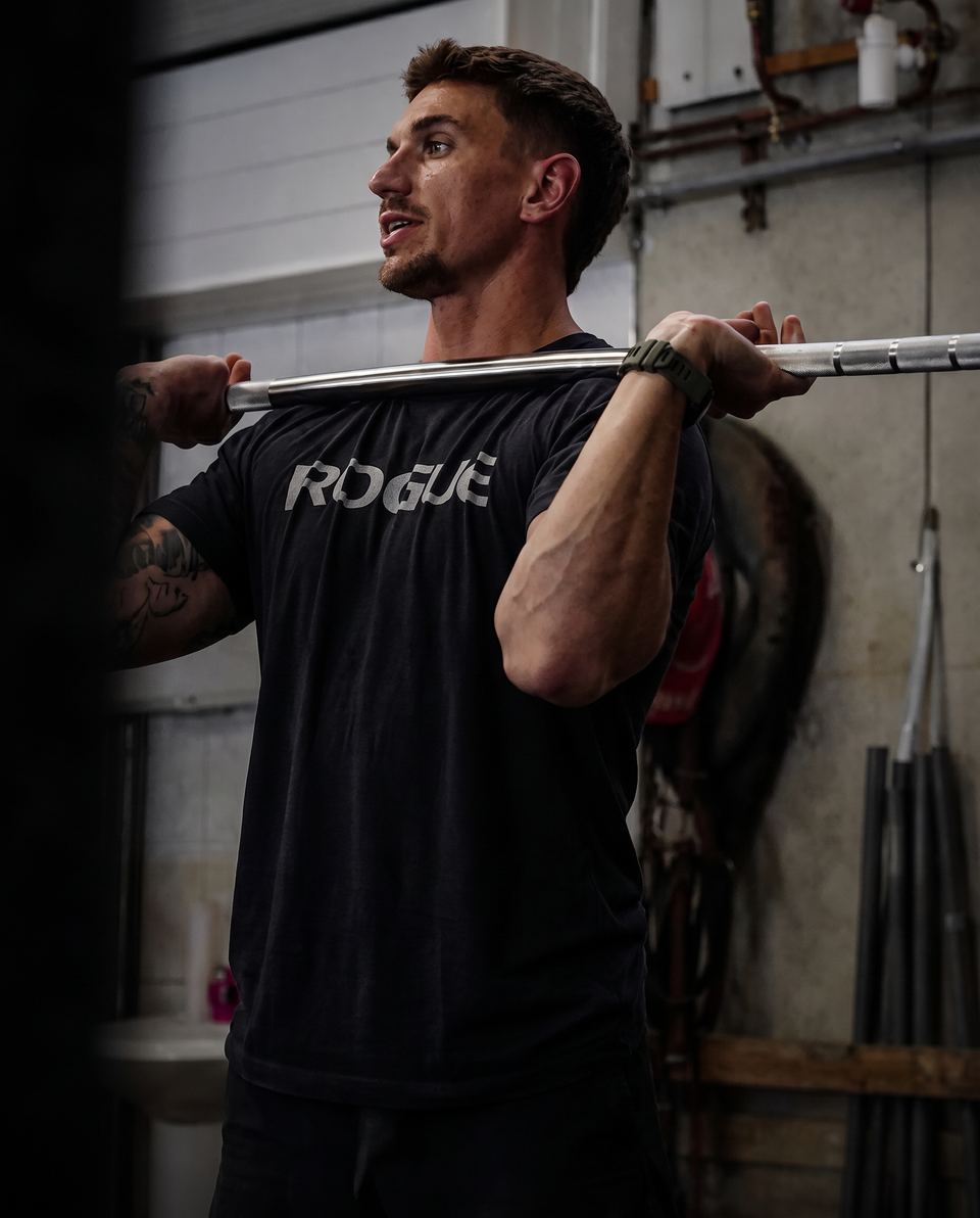 Loïc, coach de THE CAMP, une barre en position front rack dans la box